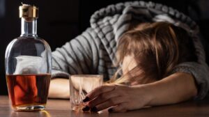 woman passed out with a bottle of alcohol