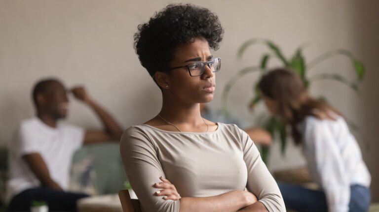 Woman sitting alone away from group