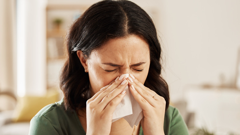 Woman blowing her nose