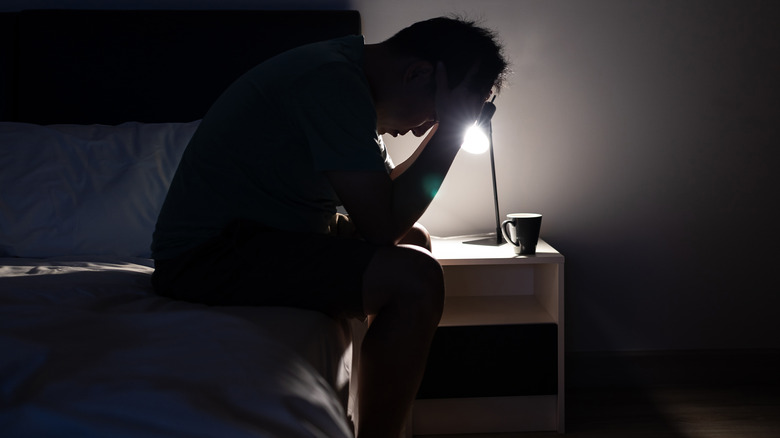 Upset man sitting on bed