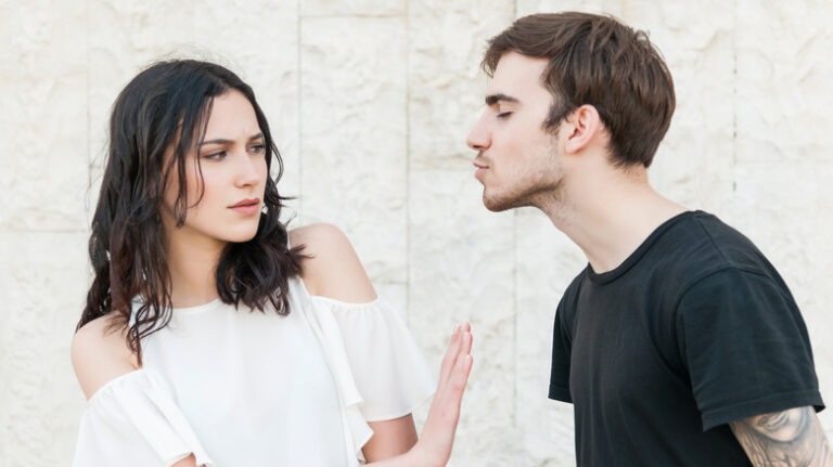 woman pushing off a kiss from a man
