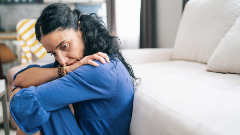 Sad woman sitting on floor