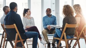 diverse group therapy session seated in chairs in a circle