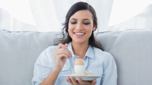 Woman eating egg for breakfast