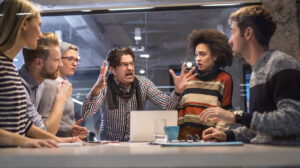 Angry manager yelling at co-workers at a meeting
