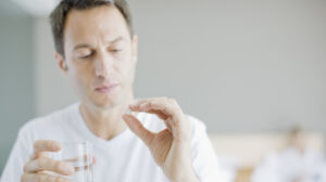 man looking at a pill