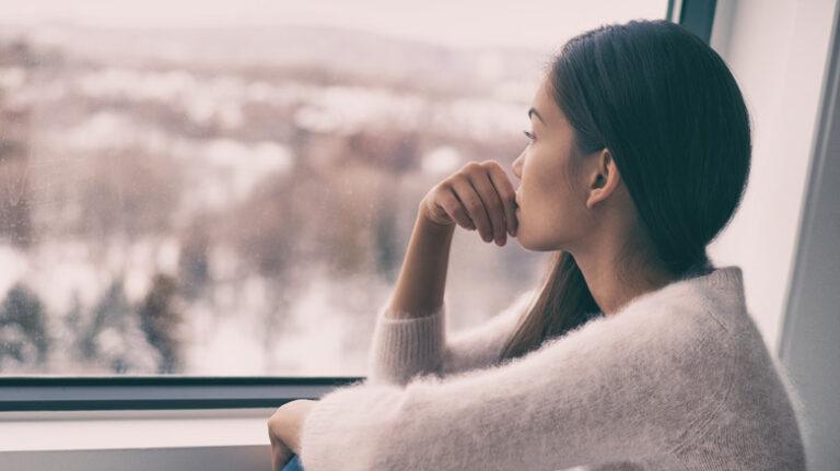 woman looking out window in winter