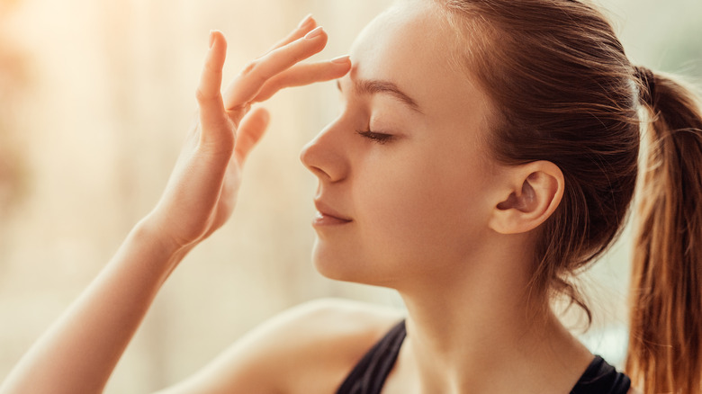 woman touching her forehead