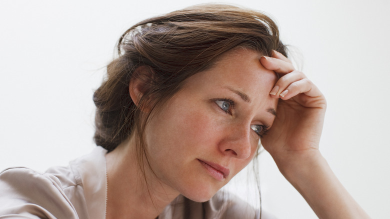 Woman appearing sad with white background