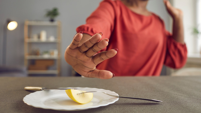 Woman rejecting plate of food
