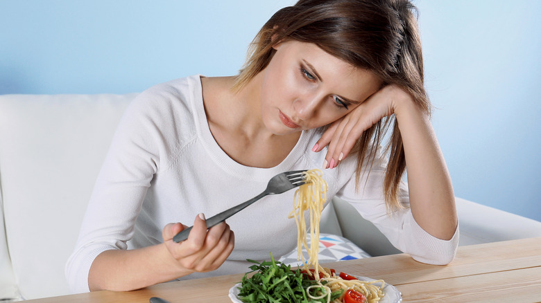 Girl looking sadly at her food