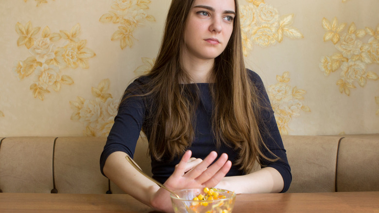 Girl pushing her food away