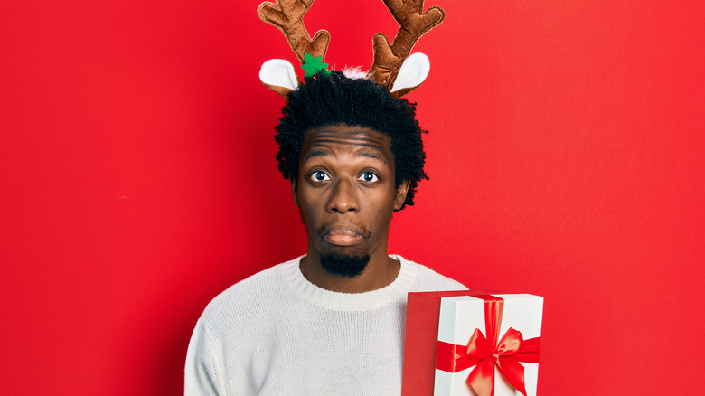 man with antler headband and present