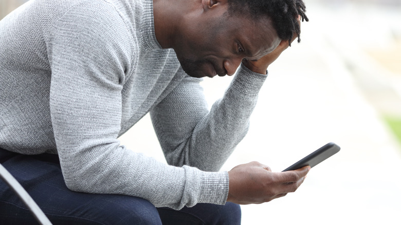Man on bench looking at phone