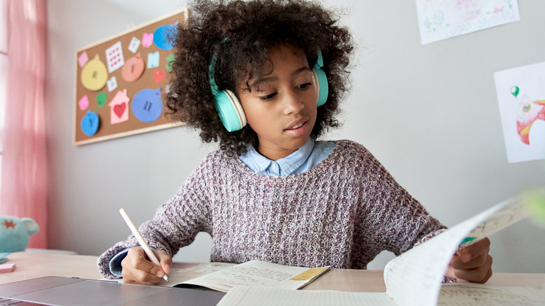 child using computer while doing schoolwork
