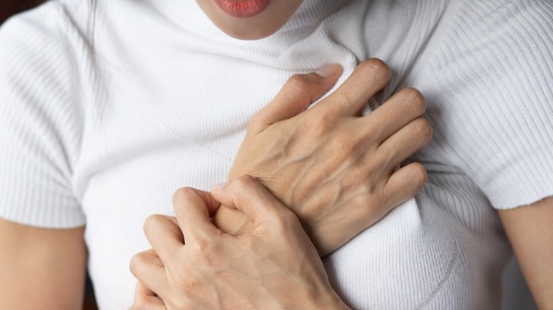 Woman clutching chest in pain