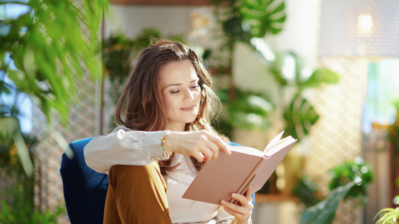 woman sitting and smiling among many house plants