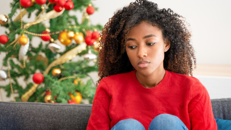 Woman sitting near decorative tree