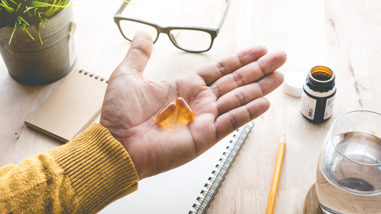 Hand holding yellow supplements