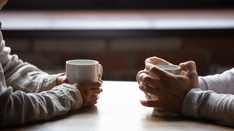 two people with coffee mugs 