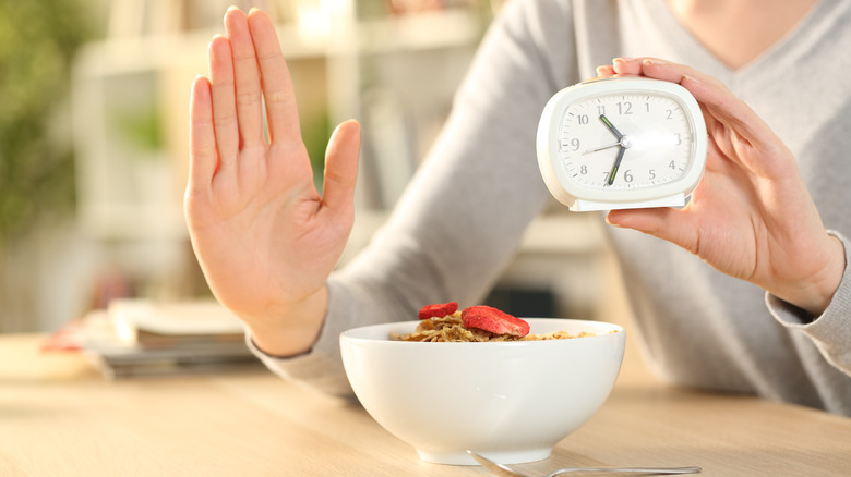 woman with clock not eating