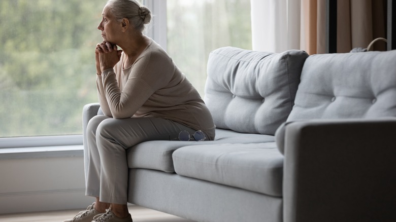 Anxious woman sits on couch