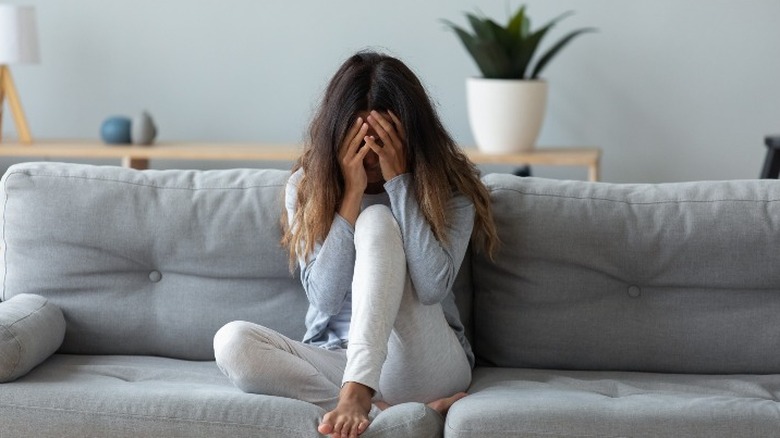 sad woman with hands covering face 