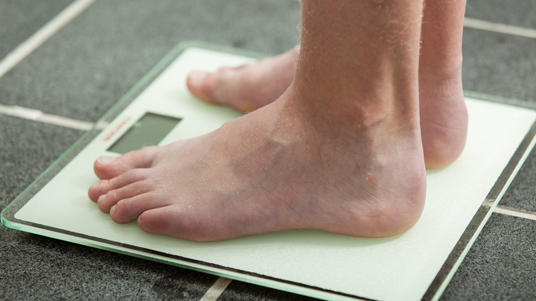 man on scale checking weight