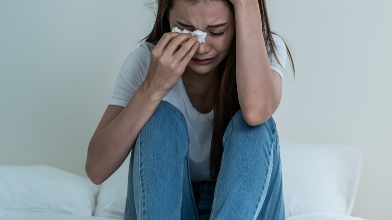 Woman sitting in bed crying 