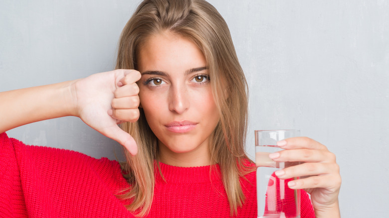Woman turning her thumb at water