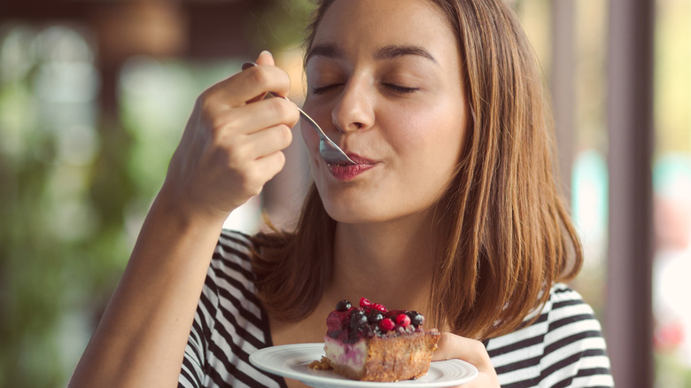 young woman savoring cheesecake