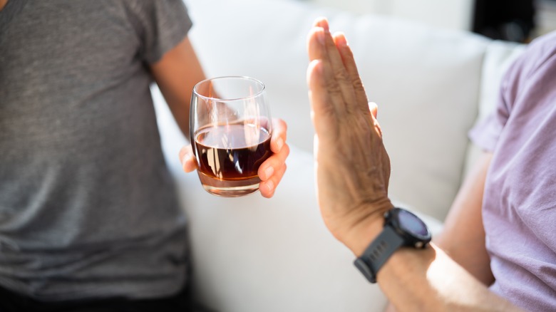 man refusing glass of alcohol