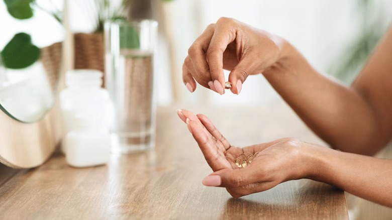 Woman holding vitamin capsules
