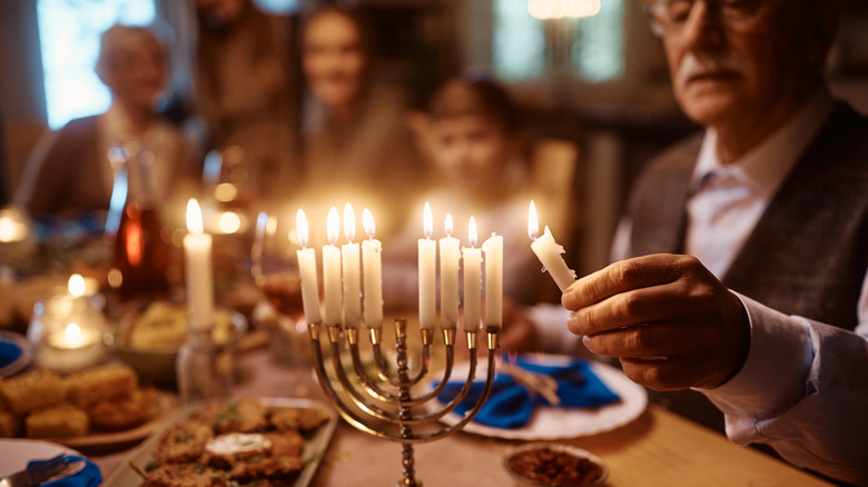 Man lighting a menorah 