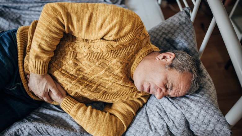 Older man holding stomach in pain