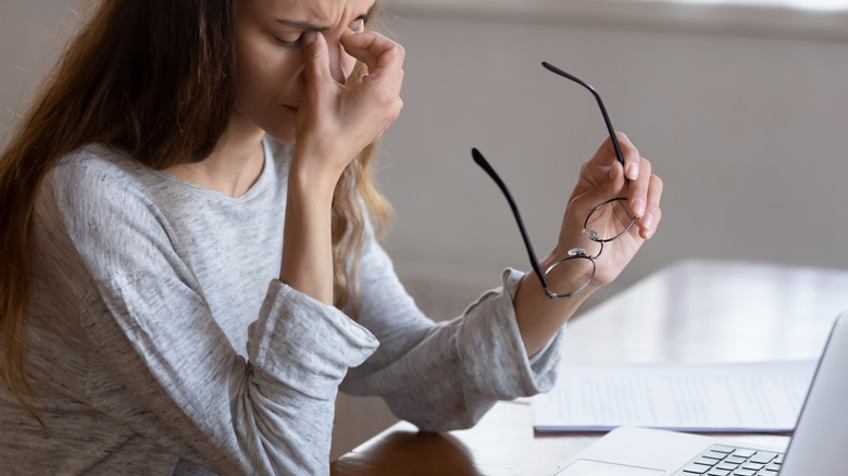  woman at computer holds glasses