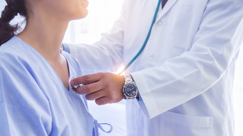 Woman going to see heart doctor listening to chest 
